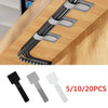 Reusable adhesive cable ties in black, silver, and white are shown being used for desk organization.