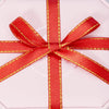 Red satin ribbon tied in a bow with gold edges, displayed on a white background.