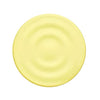 A round, pale yellow silicone product with a textured, ripple-like surface.
