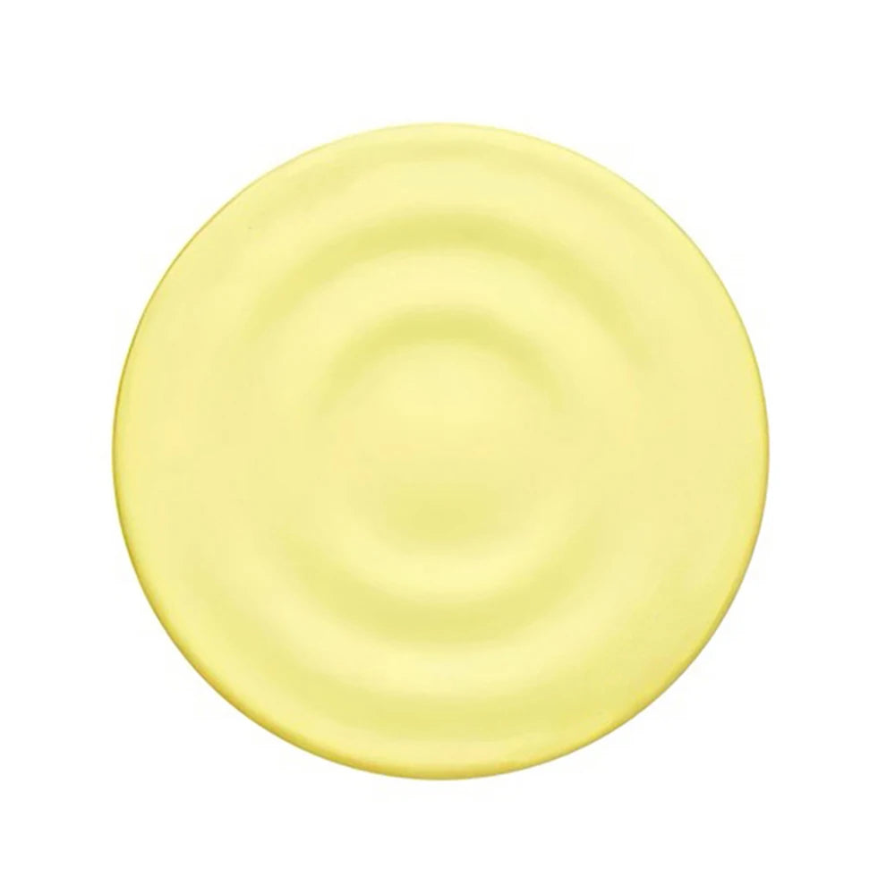 A round, pale yellow silicone product with a textured, ripple-like surface.
