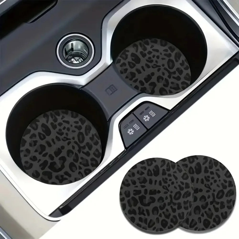 A set of two non-slip leather car cup holder coasters with leopard print texture shown in a silver holder.