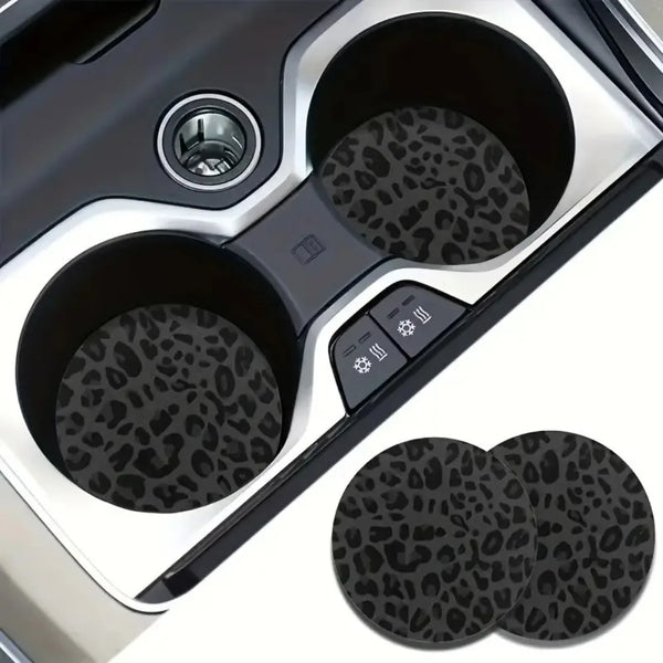 A set of two non-slip leather car cup holder coasters with leopard print texture shown in a silver holder.