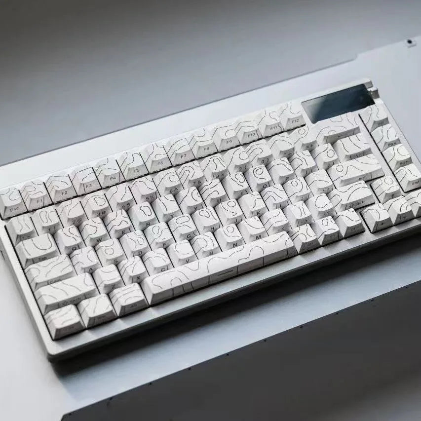 A close-up view of a white mechanical keyboard with side-lit cherry profile keycaps resting on a white surface.