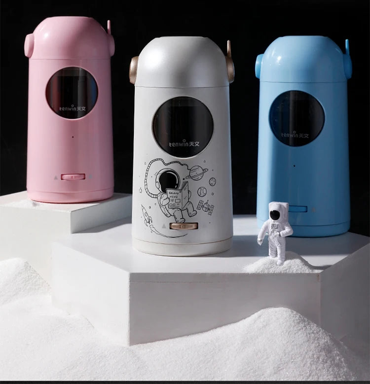 Drei elektrische Bleistift-Schärfer in rosa, weiß und blau auf einem weißen Sockel mit weißem Pulver.