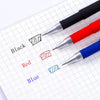 Un set de bolígrafos de gel multicolor en negro, rojo y azul escribiendo en papel cuadriculado.