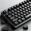 A close-up view of black PBT double-shot cherry profile keycaps for a mechanical keyboard.