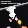 A white rabbit figure is suspended by a clear stick, demonstrating strong stickiness and standing upright without falling.