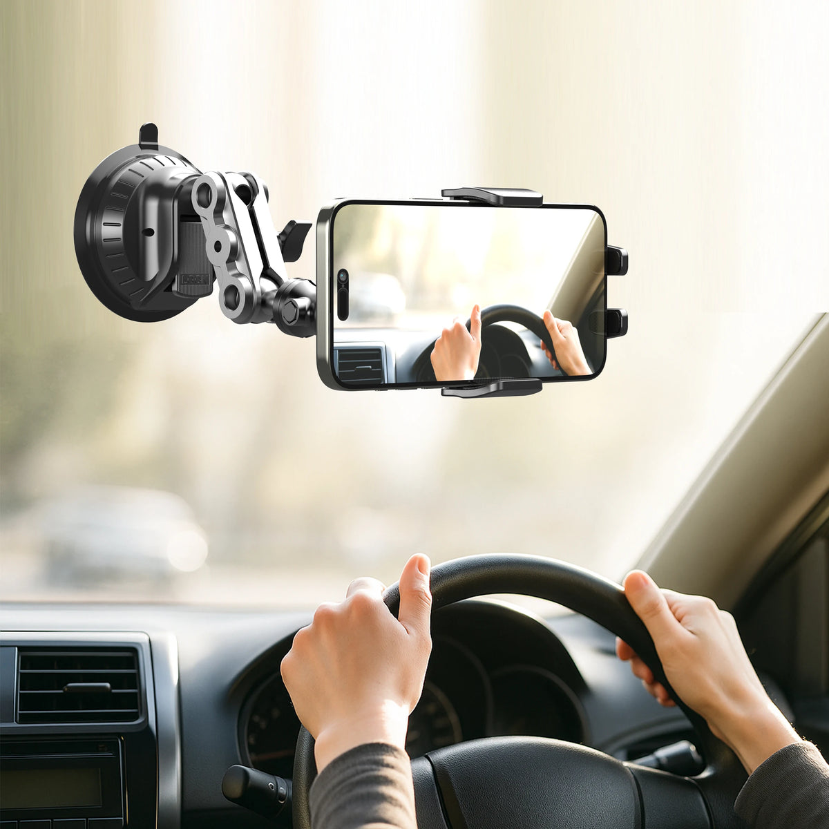 A hand is using a universal suction car phone mount with an articulating arm to hold a smartphone in a vehicle.
