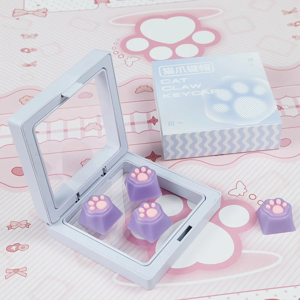 A set of purple cat paw and pink heart keycaps for MX switches displayed in their packaging.