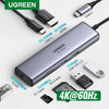 محول عسكري فضي UGREEN 7 في 1 بمنفذ USB-C، يحتوي على HDMI وEthernet ومنافذ توصيل الطاقة وكابلات وبطاقات متنوعة.