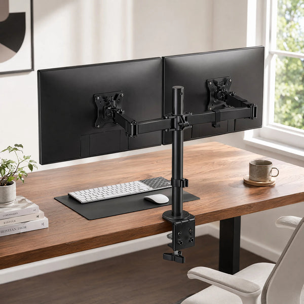 A heavy duty dual monitor desk mount holding two black computer monitors on a wooden desk.