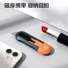 A close-up of a red and silver pocket knife with an orange grip resting on a white surface next to a smartphone.