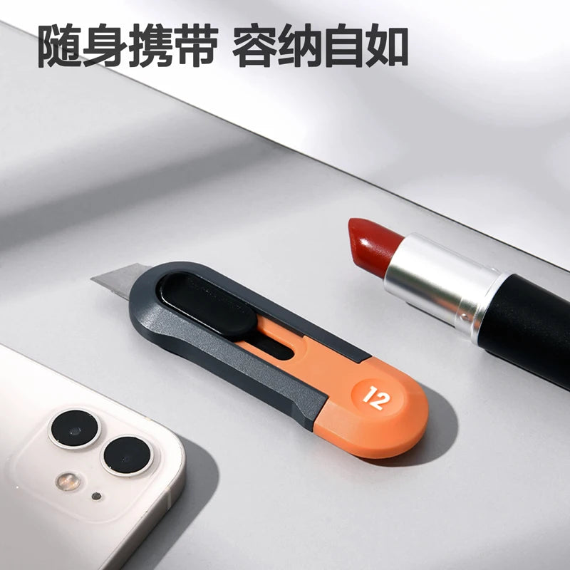 A close-up of a red and silver pocket knife with an orange grip resting on a white surface next to a smartphone.