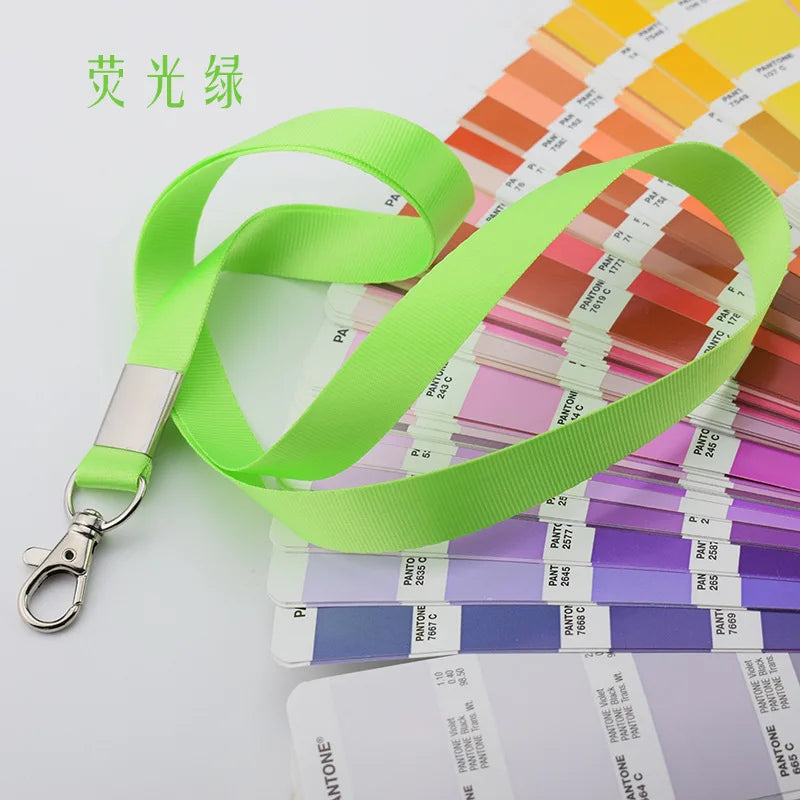 Lanyard resistente verde lima brillante para soporte de credencial, mostrado contra muestras de color Pantone.