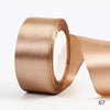 A roll of satin ribbon in a champagne gold color, shown from the side.