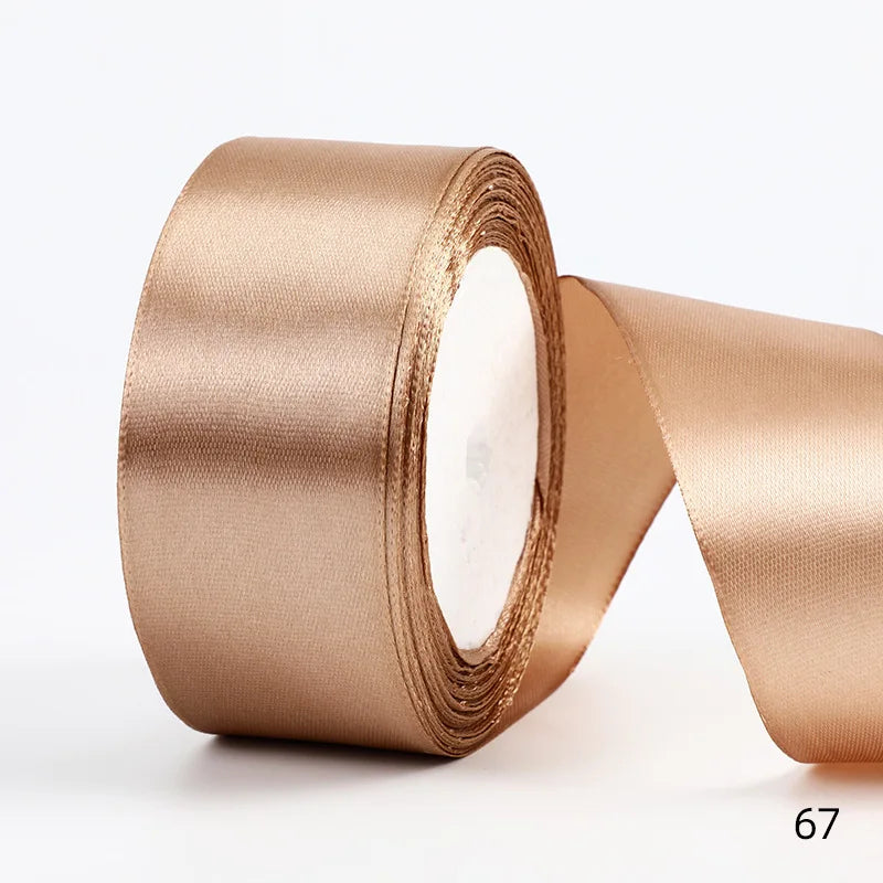 A roll of satin ribbon in a champagne gold color, shown from the side.
