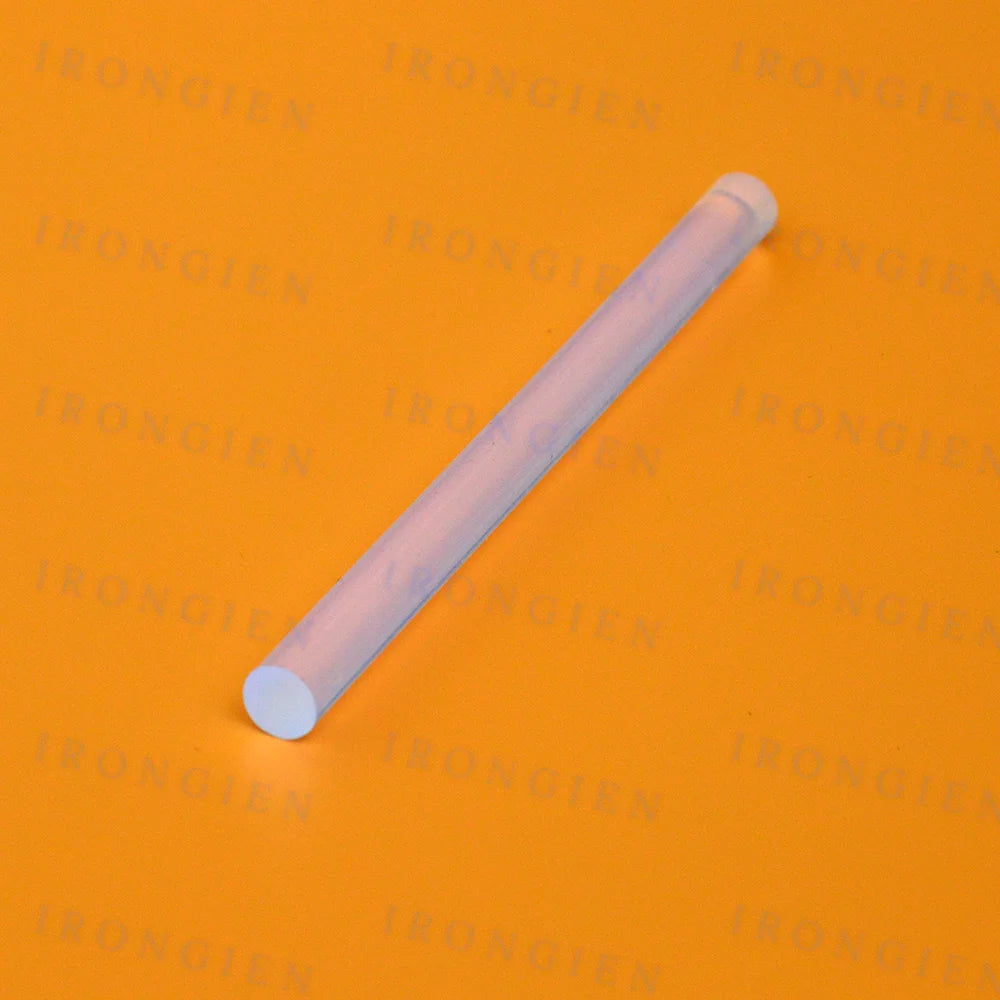 A clear hot melt glue stick is shown diagonally against an orange background.