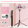A black selfie stick with a camera, Bluetooth remote control, and LED lights is displayed against a pink background.