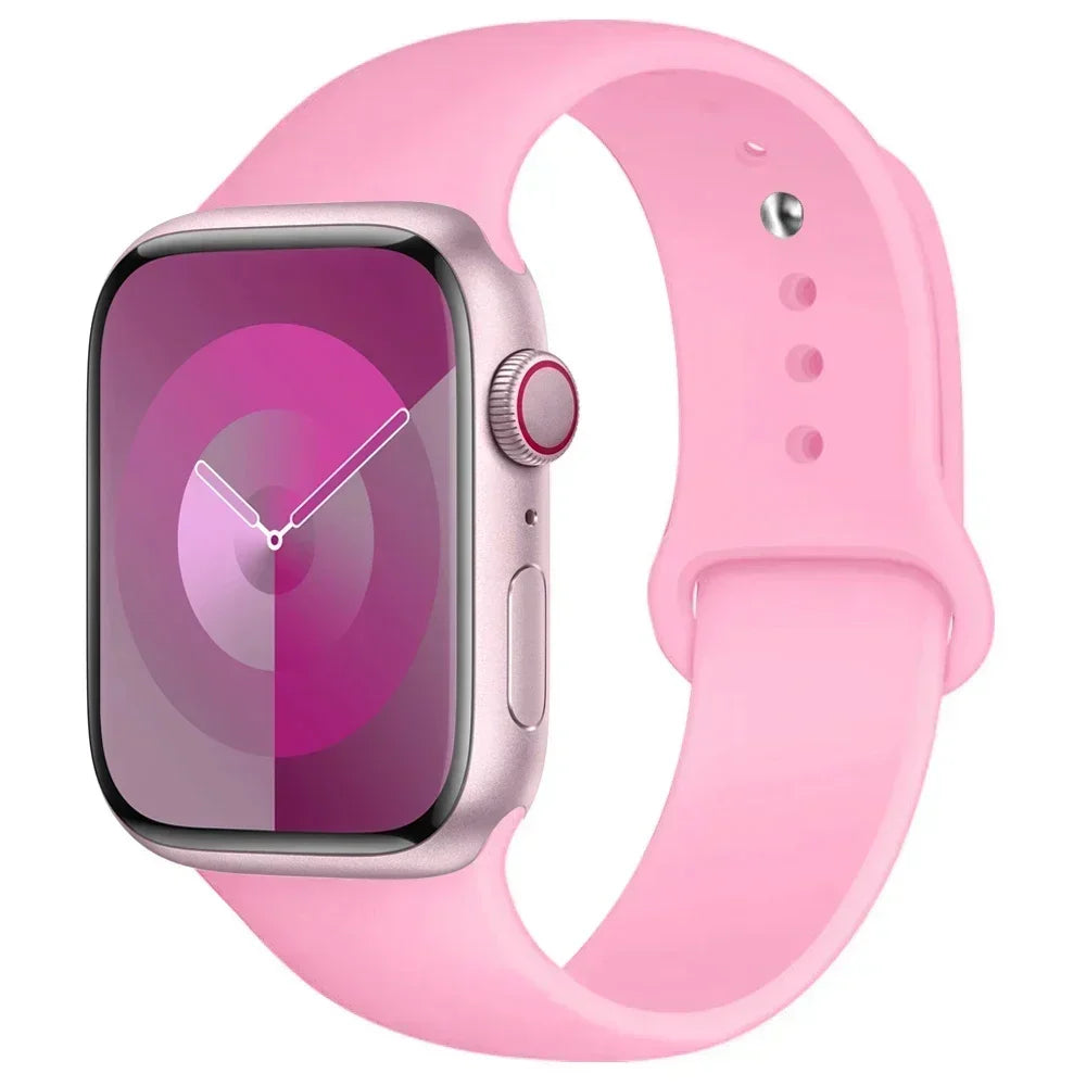 A pink silicone sport band worn around a silver Apple Watch.