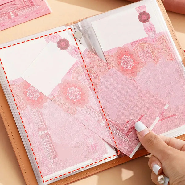 A close-up of a pink personal finance budget binder with a lock, showing decorative paper inserts.