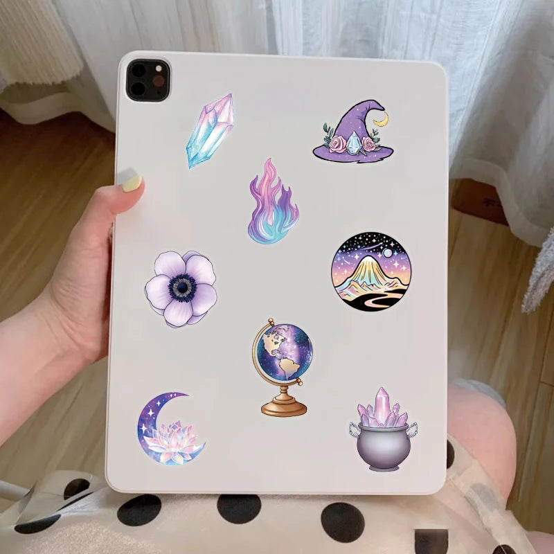 A white phone case decorated with purple magic witch stickers including a crystal, a witch hat, a moon, and a moon phase.