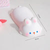 A white, cute, ergonomic wrist rest shaped like a rabbit is shown on a white surface.