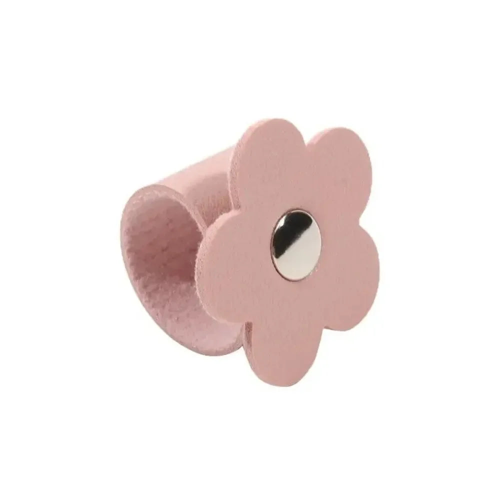 A pink leather flower cable organizer used as a reusable cord winder.