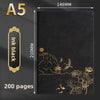 A black notebook with gold foil illustrations of mountains, pagodas, birds, and flowers on the cover.