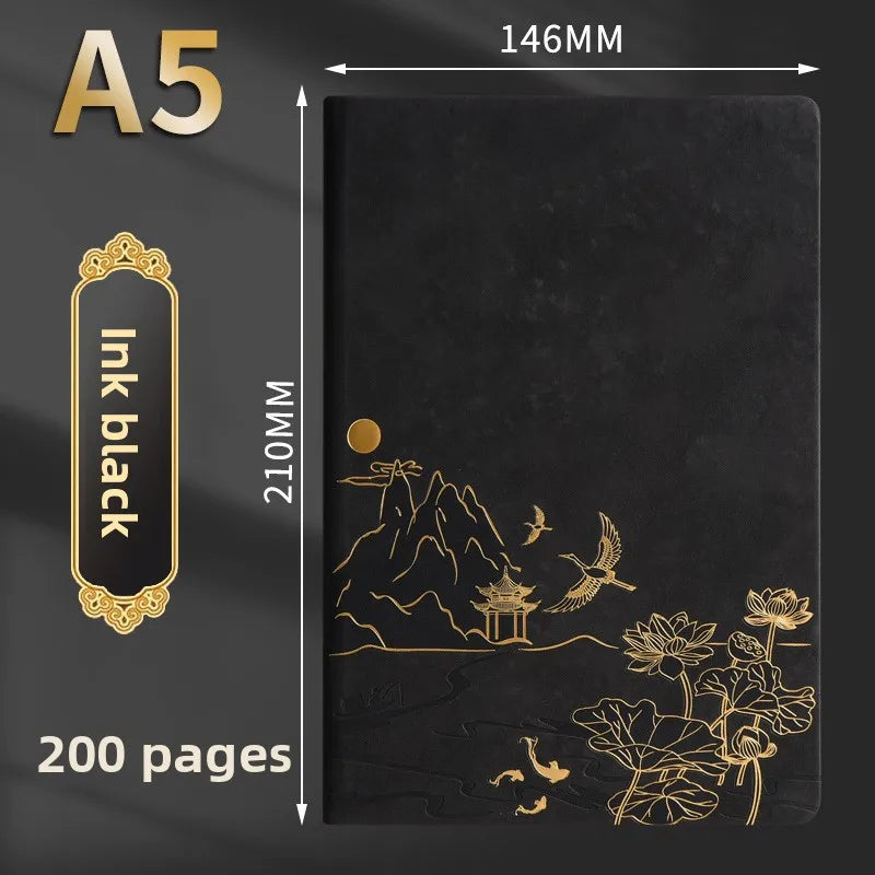 A black notebook with gold foil illustrations of mountains, pagodas, birds, and flowers on the cover.