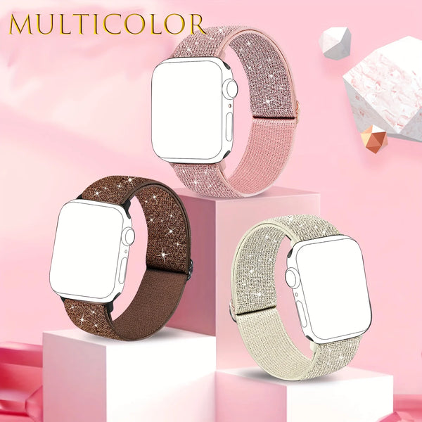 A multicolored Apple Watch with a glitter nylon strap displayed on pink pedestals.