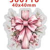 A pink wooden cross with a bow surrounded by floral greenery and leaves.
