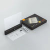 A rechargeable acrylic book night light with a timer is shown in its packaging box and with an included charging cable.