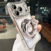 A clear iPhone case with a magnetic stand and lens protection is held up against a blurred background.