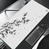 حصيرة ماوس ألعاب بيضاء بنقوش زهور سوداء دقيقة مع فأرة كمبيوتر عليها.
