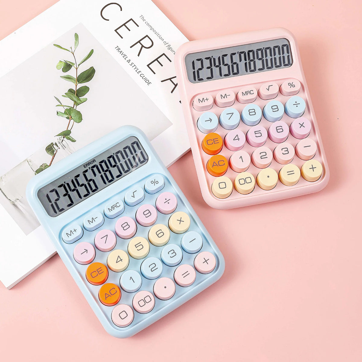 A pink mechanical 12-digit calculator with round keys is shown next to a light blue version on a pink background.