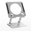 A silver foldable tablet and phone stand with a circular holder and a flat base.