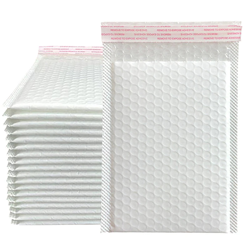 A stack of white padded bubble mailers with self-seal closures.