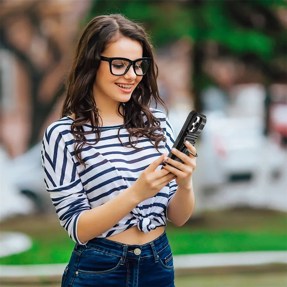 A young woman wearing glasses and a striped shirt holds a black phone case with a magnetic ring kickstand.