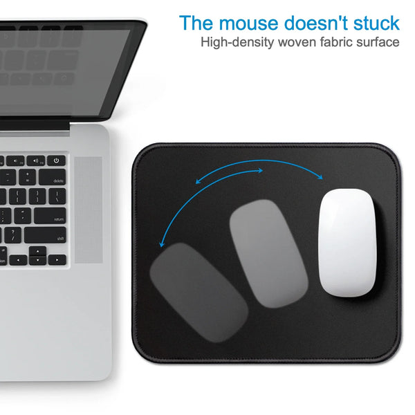 A black mouse pad with a stitched edge is shown next to a silver laptop, demonstrating its non-stick surface.