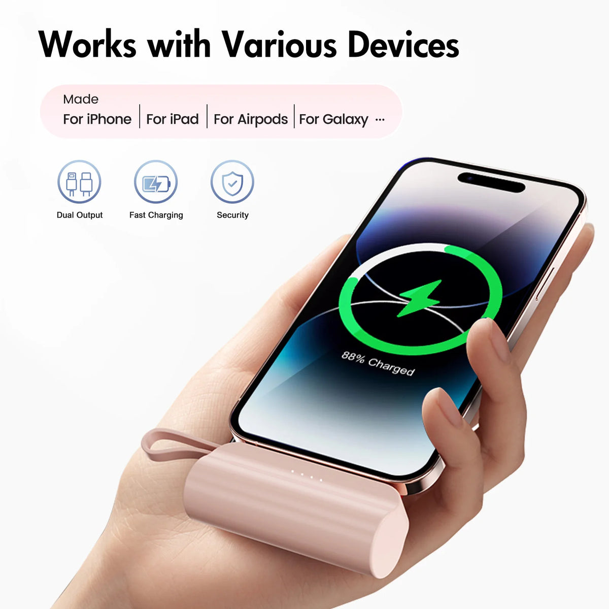 A hand holds a pink compact power bank with a USB-C port, demonstrating dual output and fast charging features.