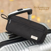 A black multi-layer stationery storage pencil case is shown resting on a silver suitcase.