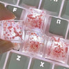 Close-up of translucent pink botanical resin keycaps resting on a mechanical keyboard.