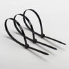 Three black heavy-duty nylon cable ties with self-locking design laid out on a white surface.