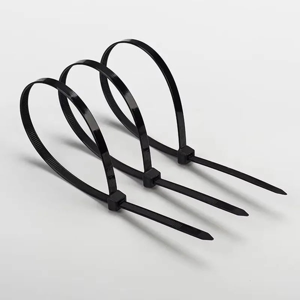 Three black heavy-duty nylon cable ties with self-locking design laid out on a white surface.