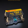 A yellow Kodak memory card is shown with electrical sparks emanating from it, resting on a circuit board.