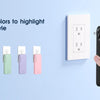 A hand holds a black portable charger next to a display showing various colored versions.