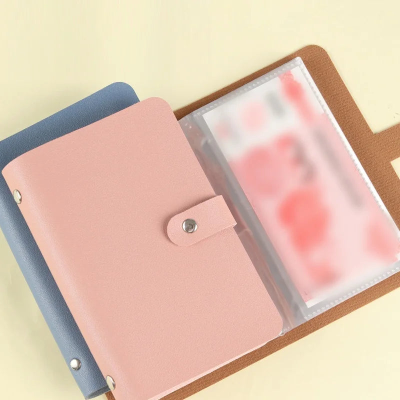 A pink reusable envelope binder with a clear plastic sleeve is shown on a brown cork board.