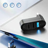 A black 4-in-1 USB hub with multiple ports is shown next to a laptop, highlighting its versatility.
