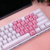 Nahaufnahme einer weißen mechanischen Tastatur mit rosa Schmetterling-Tastenkappen in einer weißen Aufbewahrungskiste.
