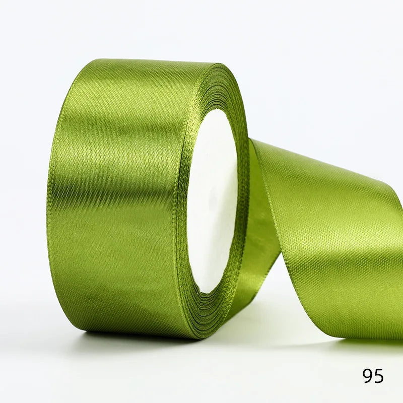 A roll of olive green satin ribbon used for gift wrapping and DIY crafts.